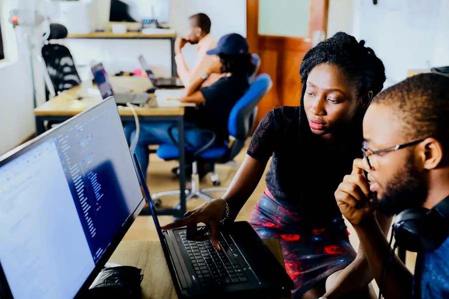 Software developers reviewing code together at a laptop